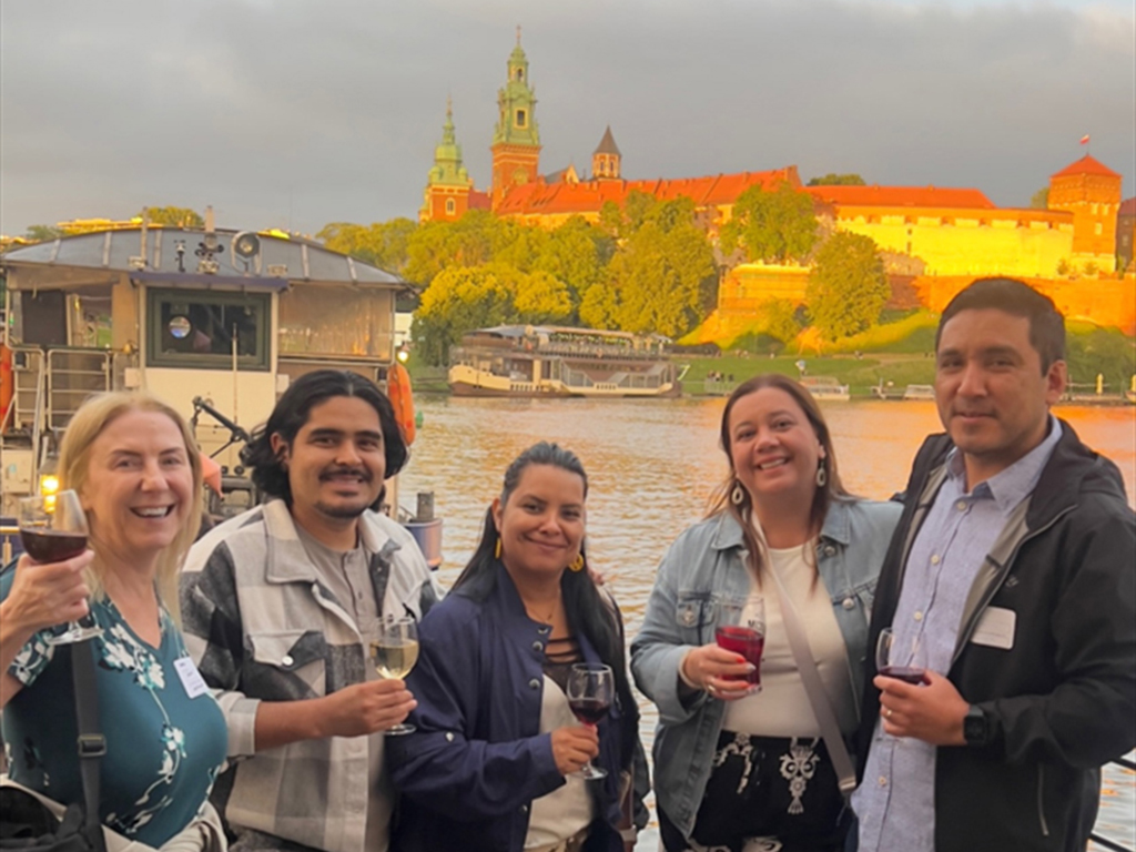 The GreenGeeks team taking a picture with the Wawel Castle in the background